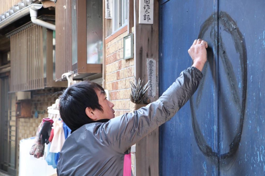 A man draw Maruhachi on his house.